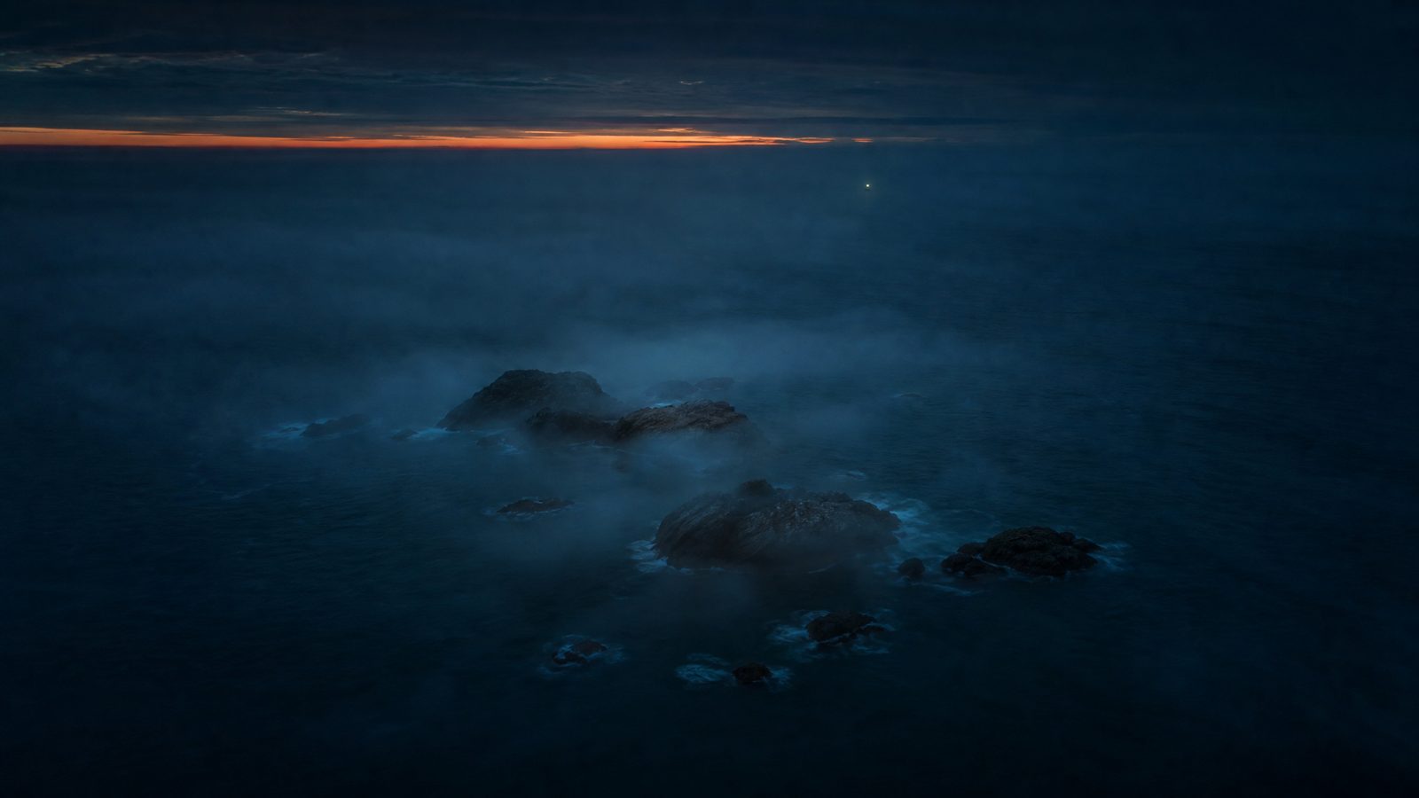 Rocky islets in sea mist at dusk